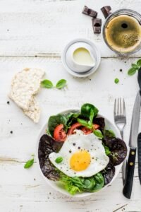 flat-lay photography of lettuce with fried egg and flatbread